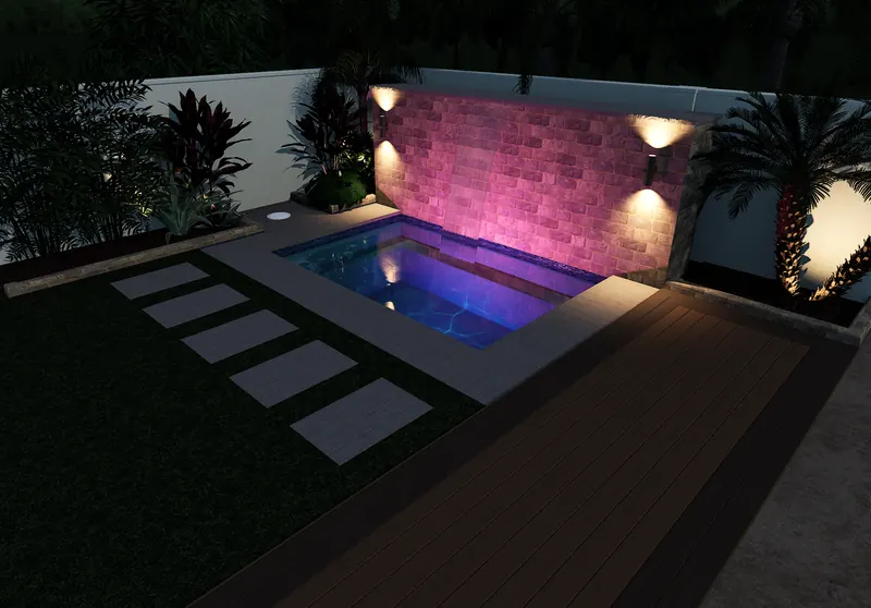 Spool with lit stone water wall at night